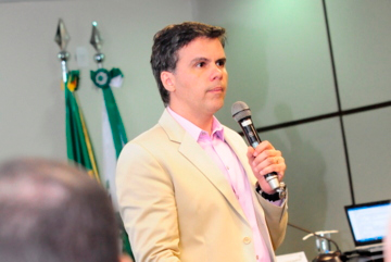 Imagem em plano médio mostra o juiz do TRT de Minas Gerais, Marcos Barroso, dirigindo-se a servidores do Tribunal Regional do Trabalho do Paraná em palestra proferida no auditório da Escola Judicial. O magistrado encontra-se de pé, falando ao microfone