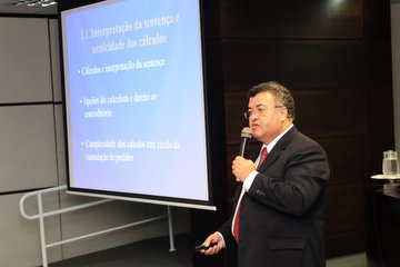 Imagem em plano geral fechado traz juiz José Aparecido dos Santos no Auditório da Escola Judicial
